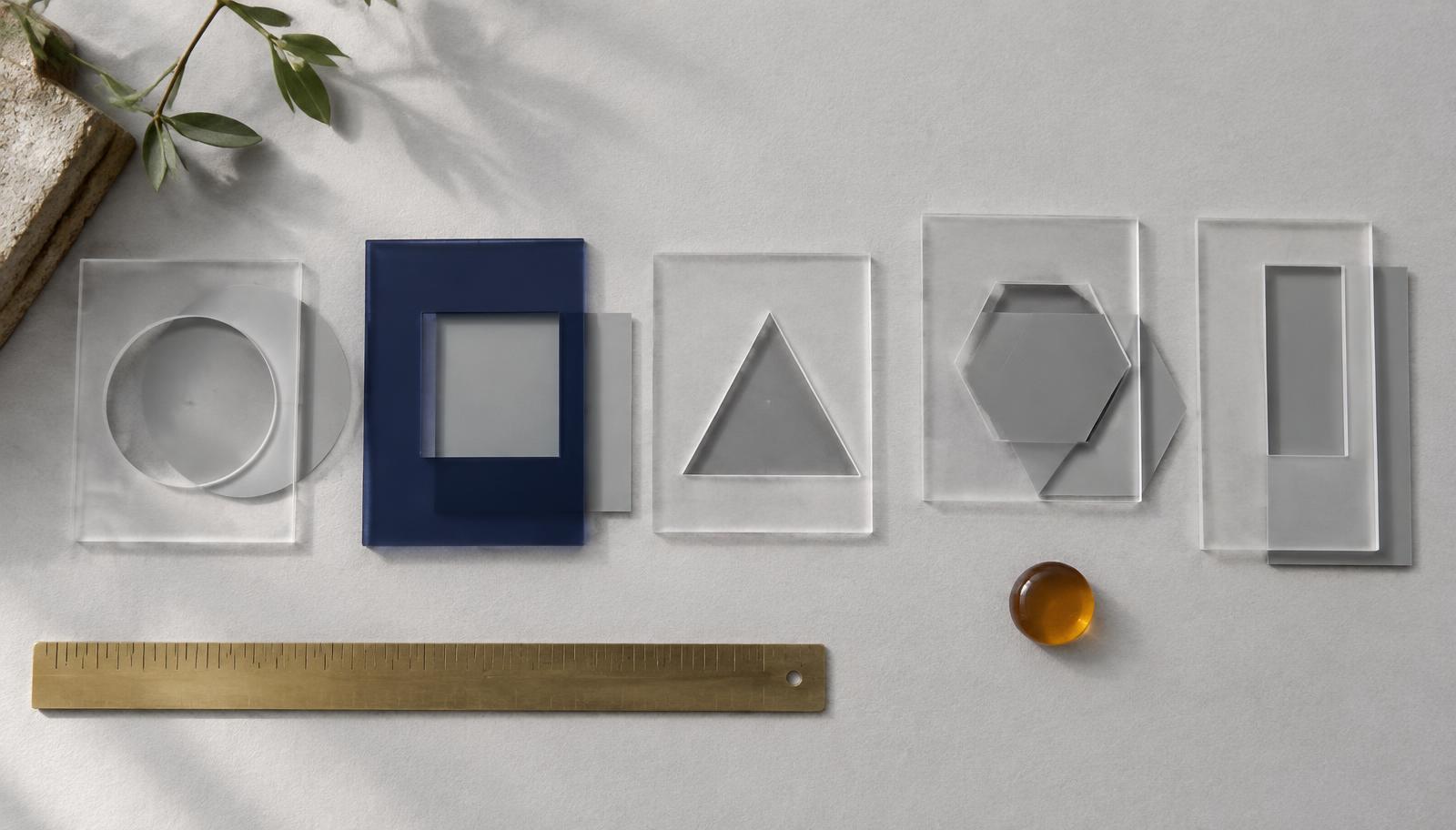 Transparent acrylic sheets with cut-out shapes, some of them lining up precisely